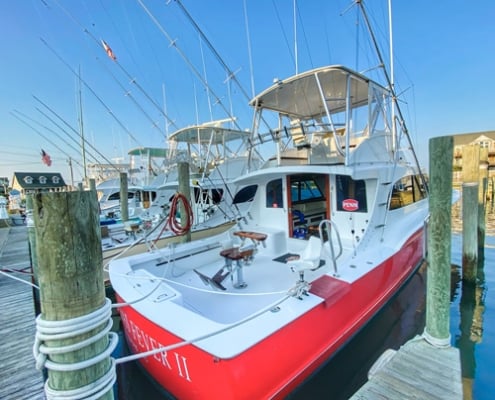 red and white boat tied to dock